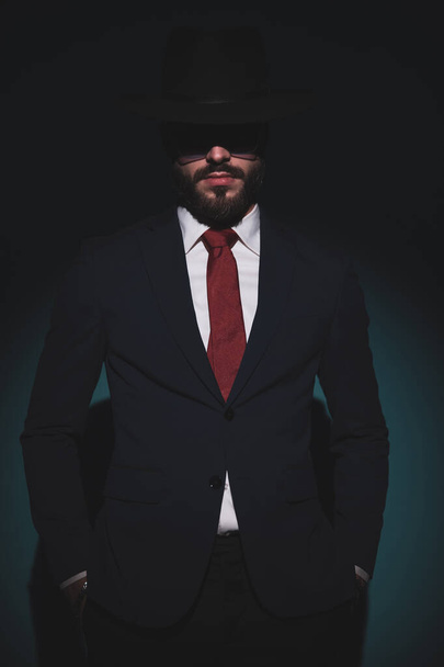 sexy businessman posing with his hands in his pockets and sending a mysterious vibe - Foto, Imagen