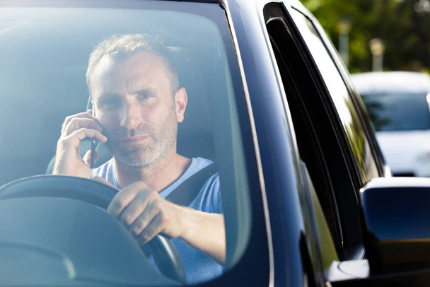 man driving a car with a phone - Фото, зображення