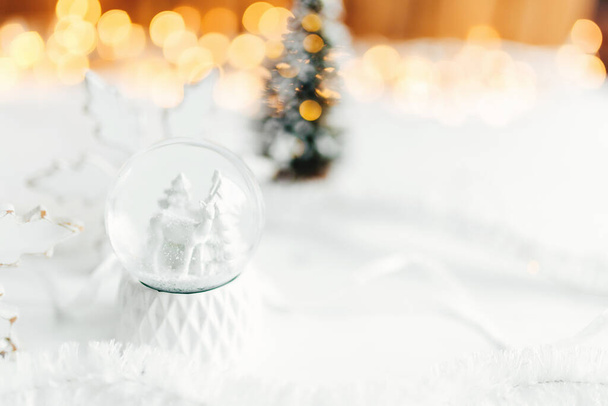 witte kerstversiering op een tafel, witte sneeuwbal en decoraties - Foto, afbeelding