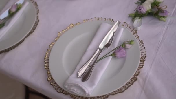 ajuste de mesa en un banquete de boda decorado con flores de lisianto - Imágenes, Vídeo