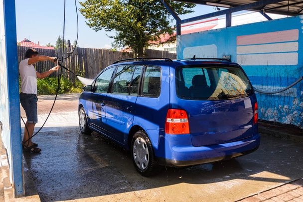 Πλύσιμο αυτοκινήτου, ξέπλυμα με περίσσεια νερού και αφρό στο αυτοκίνητο, καθάρισμα σε βρεγμένο αυτοκίνητο.2020 - Φωτογραφία, εικόνα