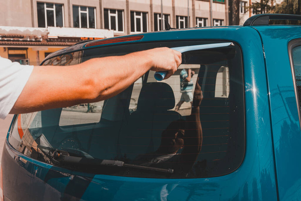 čištění automobilového skla, muž utírá přebytečnou vodu ze skla v autě.2020 - Fotografie, Obrázek