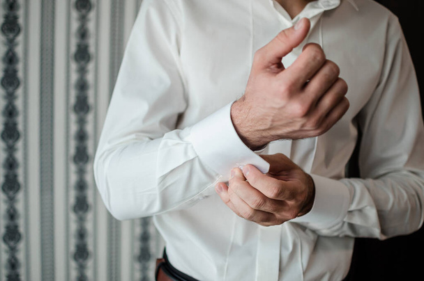 Groom's morning. The groom buttons the cufflinks on his shirt - Φωτογραφία, εικόνα