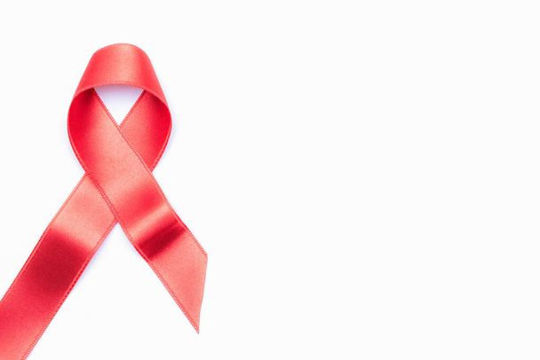 Wsparcie Hiv. Czerwona wstążka symbol w hiv świecie dzień izolowany na białym tle. Pomoce informacyjne i nowotwory. Koncepcja starzenia się miesiąca - Zdjęcie, obraz