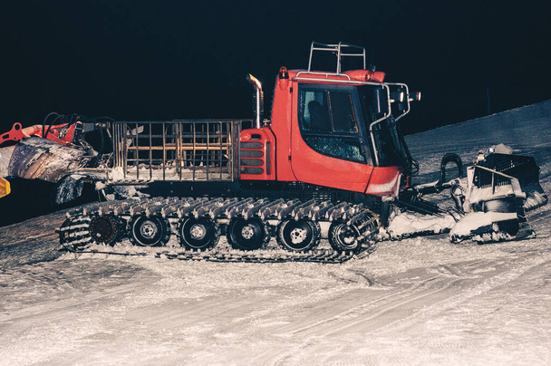 Ratrakissa. Ratrack, lumi grooming kone valmistelee rinteitä hiihtäjille hiihtokeskuksessa vuorilla. Ratrac kone hiihto rinne valmistelut vuoristossa talvella resorts. - Valokuva, kuva