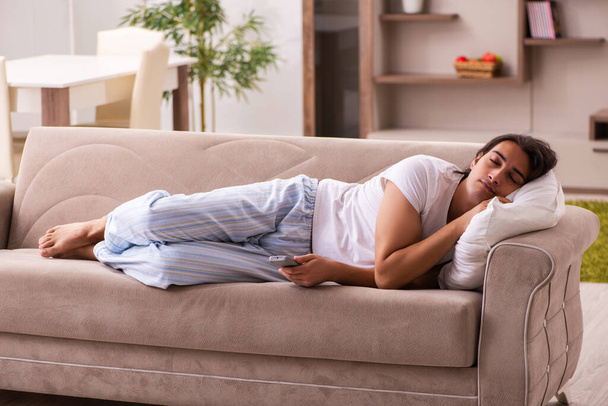 Young lazy man in oversleeping concept at home - Photo, Image