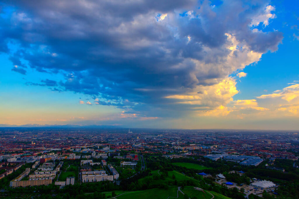 夜にはミュンヘンの上に層状の雲.街の空中パノラマ  - 写真・画像