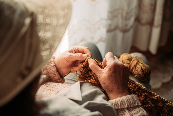 Close-up of elderly woman hands knitting. Wintertime - Фото, зображення