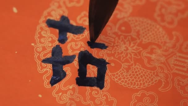 Calígrafo chino que escribe las coplas del festival de primavera, estos caracteres chinos significan "primavera" o "felicidad" - Metraje, vídeo