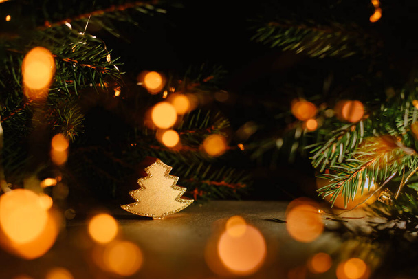 Gyertya karácsonyfa homályos sötét háttérrel, arany bokeh koszorúval. Karácsonyi gyertyatartó, 2021 újév. Másolás, oldalnézet. Kényelmes elem dekoráció. Piaci értékesítés. - Fotó, kép