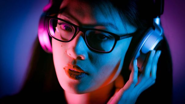 Young Asian woman listens to music - strong colorful shot - Zdjęcie, obraz
