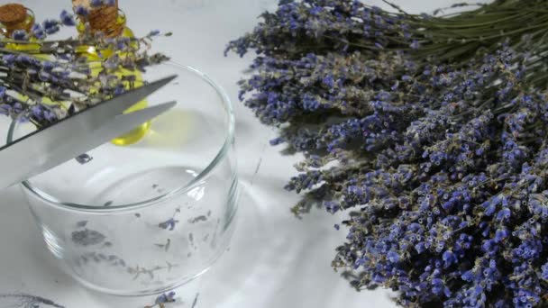 Cutting of dry lavender flowers into glass on table - Footage, Video
