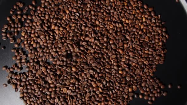 Vallende gebrande koffiebonen op donkere achtergrond, bovenaanzicht - Video