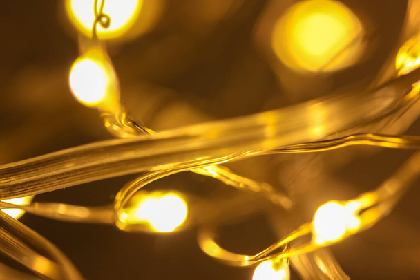 Luzes amarelas da guirlanda de Ano Novo close-up, fundo festivo de volta borrado - Foto, Imagem