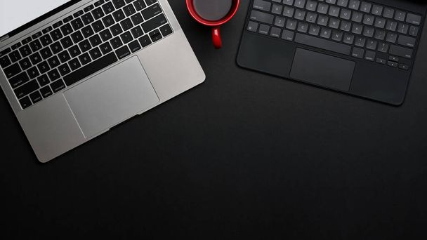 Vue du dessus de la table noire avec espace de copie, clavier d'ordinateur portable et de tablette dans la salle de bureau, inclure le chemin de coupe - Photo, image