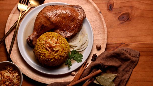 Top view of delicious chicken biryani with rice marinated in spices on wooden table - Foto, afbeelding
