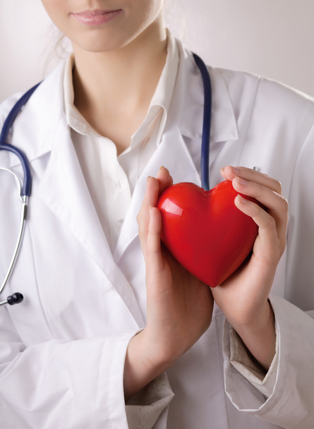 Female doctor with stethoscope holding heart - Фото, зображення