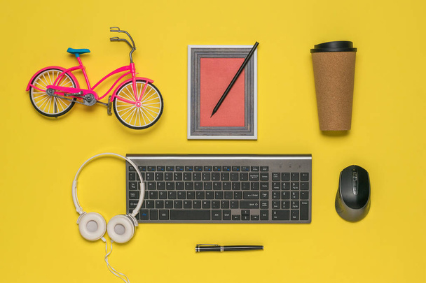 Tastiera wireless, mouse, cuffie e accessori di design su sfondo giallo. - Foto, immagini