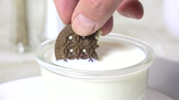 Dunking a chocolate sandwich cookie in milk - Záběry, video