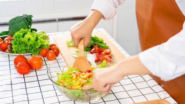 mujer en el proceso de preparación de alimentos saludables Ensalada Vegetal mezcla de ensalada cuchara de madera en la cocina en casa Concepto de dieta. - Foto, Imagen
