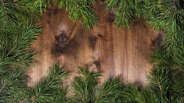 Koyu kahverengi ahşap arka planda çam ağacı dalları - Fotoğraf, Görsel