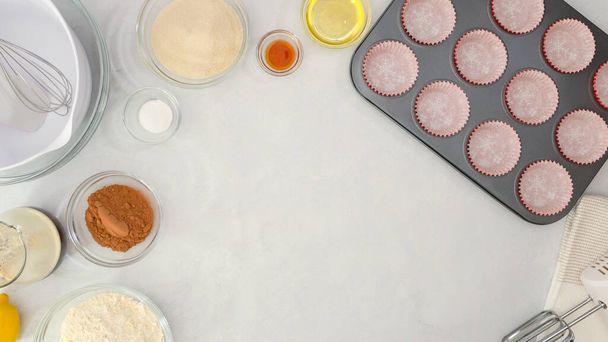 ペーパーカップケーキライナーとマフィンパン,キッチンテーブルの上に閉じチョコレートマフィンレシピのための成分.コピースペース付きフラットレイアウト - 写真・画像
