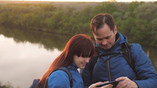 Bir adam ve bir kız seyahat ederken telefonda selfie çekiyorlar. Baba ve kızı akıllı telefondan fotoğraf çekiliyor. Çocuklu bir baba, turist hayatında macera arıyor. Takım çalışması. Aile - Fotoğraf, Görsel