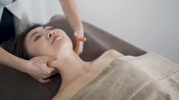 Японська жінка отримує масаж на шиї в естетичному салоні. - Кадри, відео