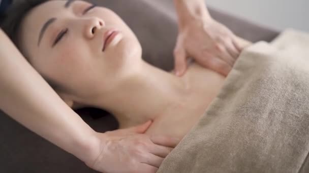 Mulher japonesa recebendo uma massagem no pescoço em um salão estético - Filmagem, Vídeo