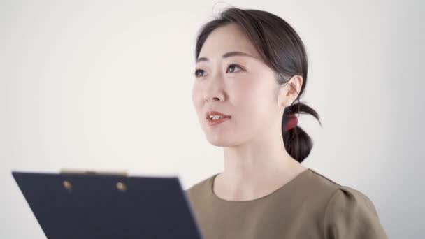 Een Japanse schoonheidsspecialiste die advies geeft in een schoonheidssalon met behulp van medische dossiers - Video