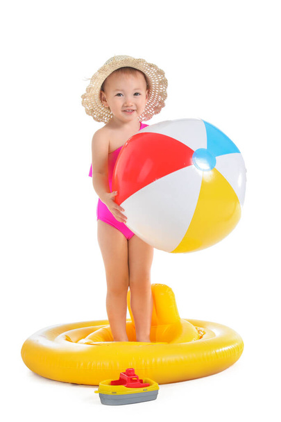 Bébé fille mignonne avec anneau gonflable et ballon de plage sur fond blanc - Photo, image