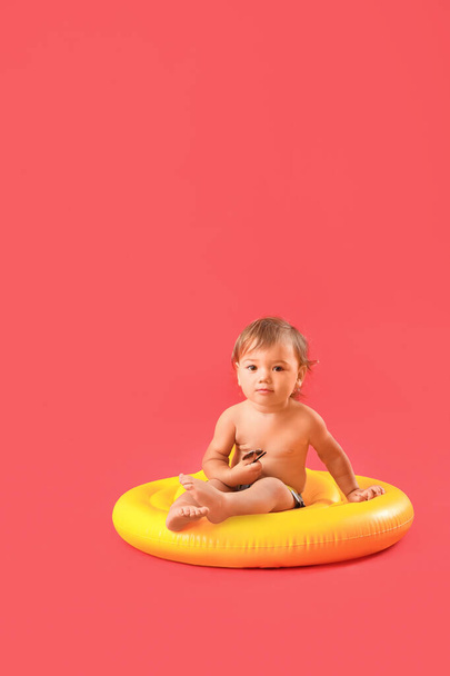 Cute baby boy with inflatable ring on color background - Photo, Image