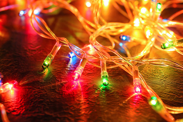 Zářící vánoční světla na tmavém pozadí, detailní záběr - Fotografie, Obrázek