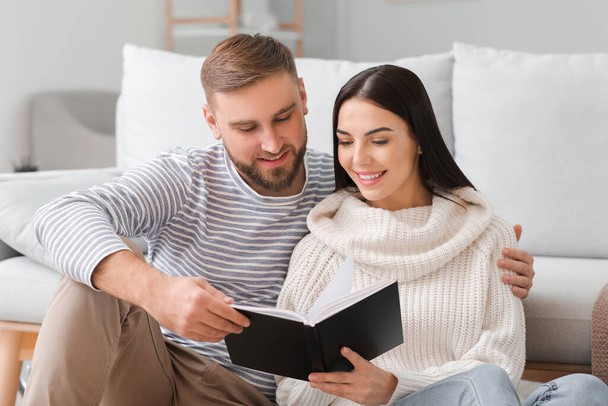 Young couple reading book at home - Foto, Imagen