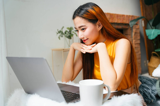 Hermosa joven asiática mujer concentrado mirando ordenador portátil. - Foto, imagen