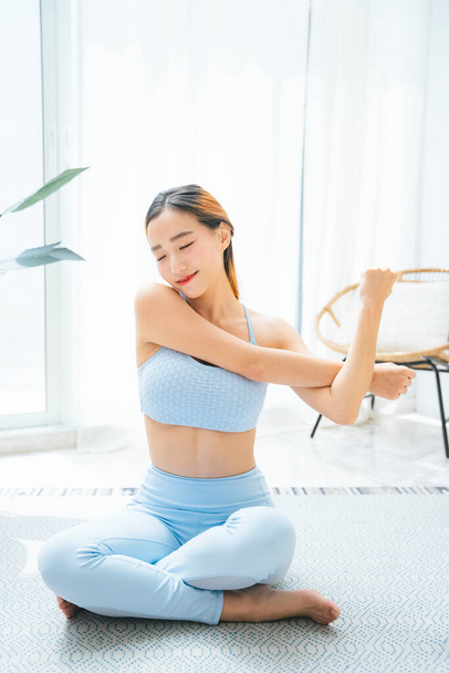 Beautiful sporty asian woman warmup stretching arms and hands on yoga mat. - Foto, immagini