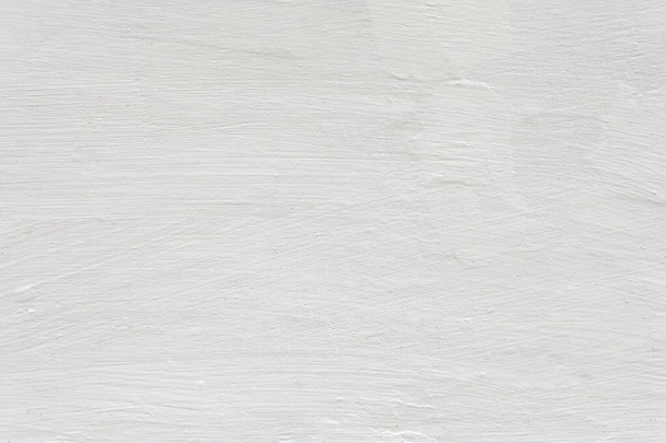 witte witgekalkte muur uniforme textuur onder zachte verlichting. reliëf whitewash licht achtergrond - Foto, afbeelding