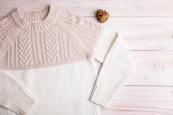 White warm knitted sweater on a wooden background. - Photo, Image