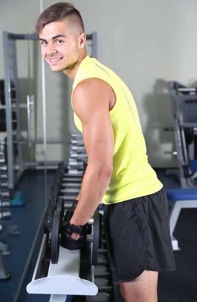 Guy with dumbbells in gym - Photo, Image