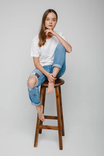 δοκιμές μοντέλου. Όμορφο κορίτσι με μακριά μαλλιά κάθεται στην καρέκλα και ποζάρουν - Φωτογραφία, εικόνα