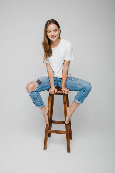 model tests. Beautiful girl with long hair sitting on chair and posing - Photo, Image
