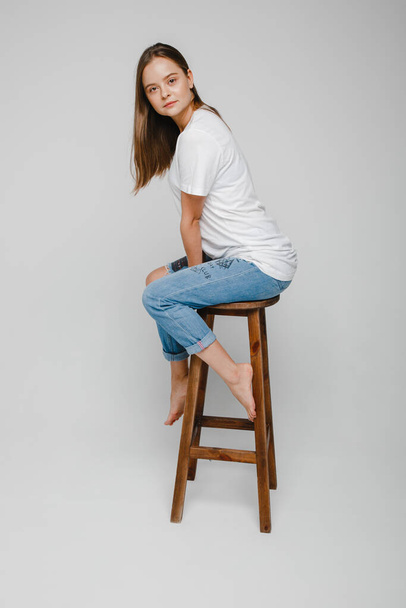 model tests. Beautiful girl with long hair sitting on chair and posing - Photo, Image