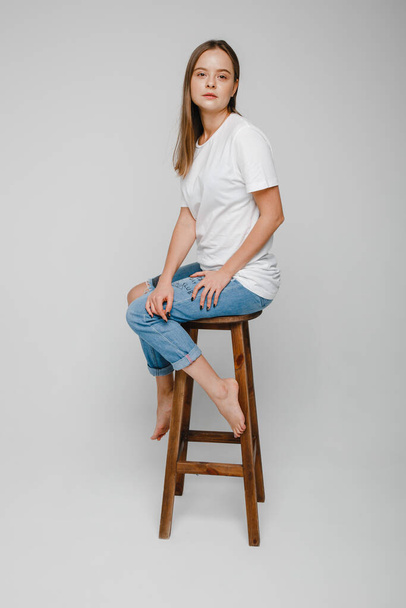 модельные испытания. Красивая девушка с длинными волосами сидит на стуле и позирует - Фото, изображение