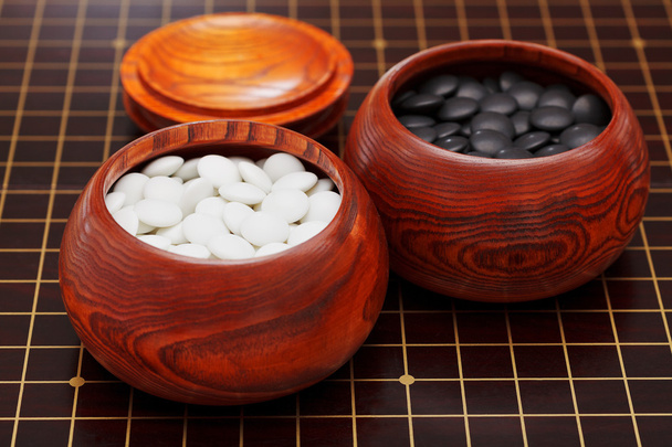 чорно-білі йдуть камені в дерев'яних мисках
 - Фото, зображення