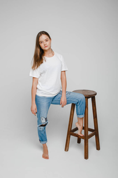 model tests. Beautiful girl with long hair stands near chair and posing - Fotografie, Obrázek