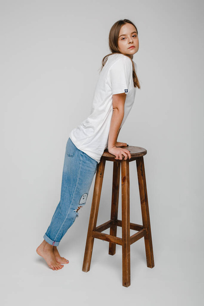 model tests. Beautiful girl with long hair stands near chair and posing - 写真・画像