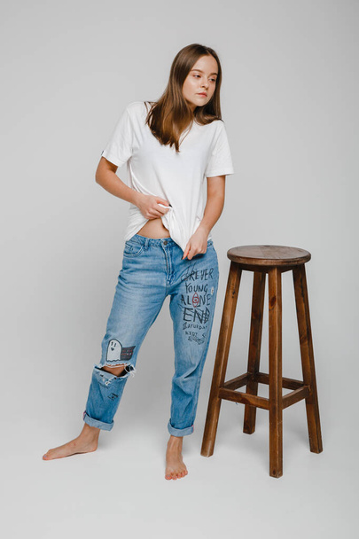 model tests. Beautiful girl with long hair stands near chair and posing - Photo, Image