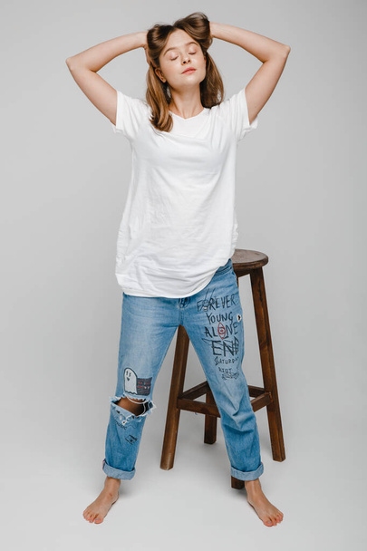 model tests. Beautiful girl with long hair stands near chair and posing - Photo, image