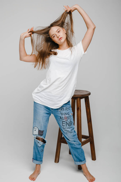 model tests. Beautiful girl with long hair stands near chair and posing - Foto, immagini