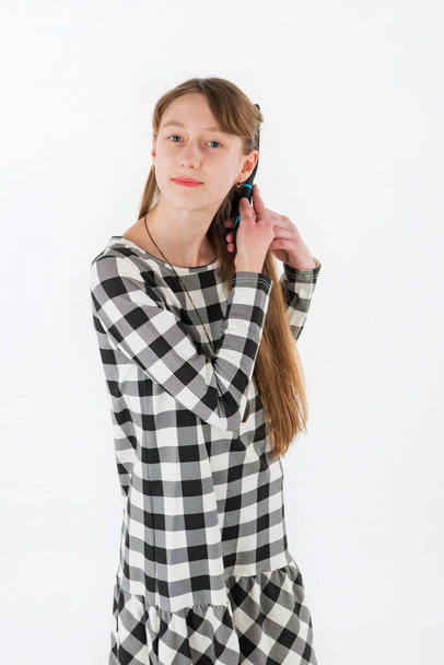 Крупним планом портрет дівчини чистить волосся на білому тлі
 - Фото, зображення